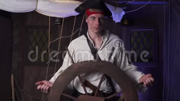 一个脸上有伤疤头上戴帽子的海盗正在转动海盗船的方向盘4K视频的预览图