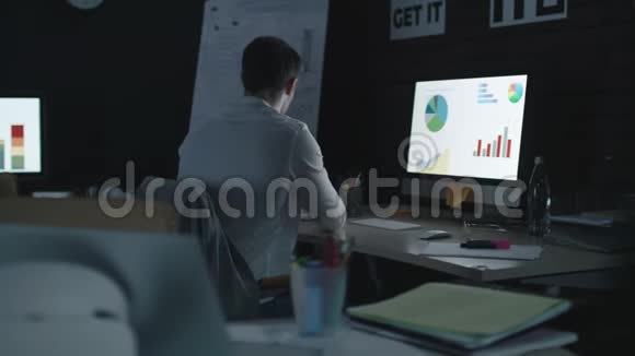 工作过度的商人分析夜间办公室的财务图表视频的预览图