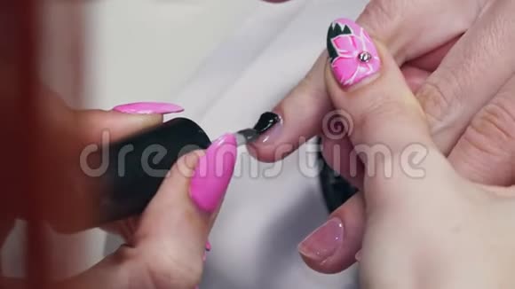 红热美甲师用无色指甲油画女孩的指甲视频的预览图