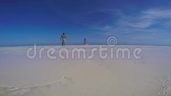 在菲律宾巴拉巴克巴拉望的曼萨兰根沙洲一对可爱的旅行夫妇在碧空的沙滩上玩耍视频的预览图