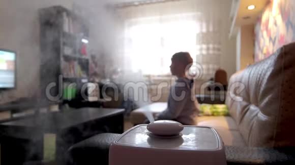 在一个有小孩的模糊房间里蒸汽从加湿器和空气电离器中流出提高室内腐殖质的气候装置视频的预览图
