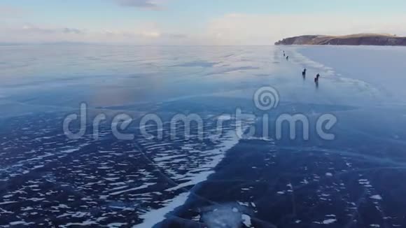 一群旅行者在冰冻的湖面上滑冰的空中景色视频的预览图