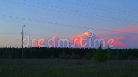 日落时分在乡村的电力线背景下运行着紫色的云时光飞逝视频的预览图