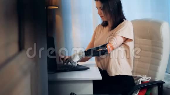笔记本电脑是由一个有仿生手臂的年轻女人操作的视频的预览图