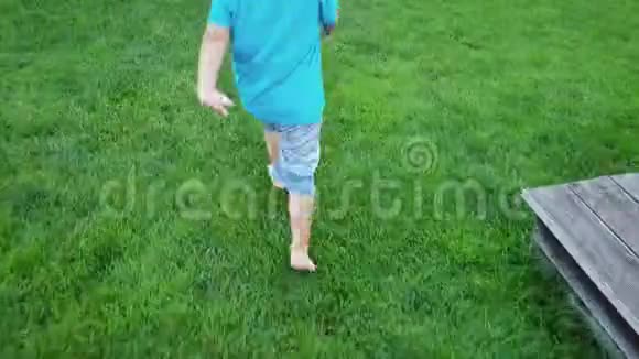 公园里赤脚学步的男孩在新鲜的绿草上奔跑的4k镜头视频的预览图