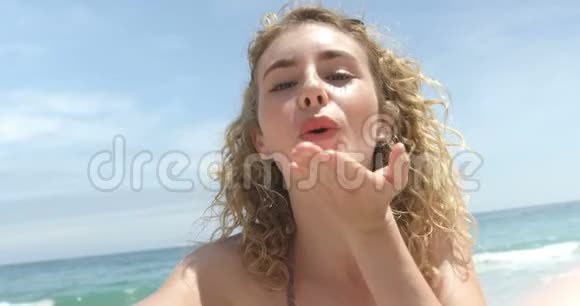 高加索女人在海滩上飞吻的正面景色视频的预览图