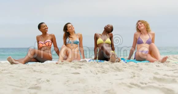 在海滩上闭着眼睛放松的混血女性朋友的正面景色视频的预览图