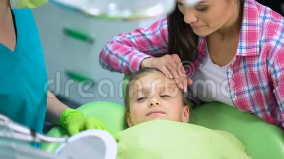 可爱的孩子在牙科手术后微笑在镜子里看健康的牙齿视频的预览图