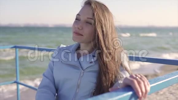 轮椅上的残疾青年妇女在斜坡上靠海休息视频的预览图