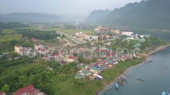 小镇坐落在广阔的蓝色河岸灰色的天空下视频的预览图
