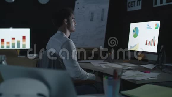 疲劳的商业分析人员睡在办公室的桌子前电脑屏幕上视频的预览图