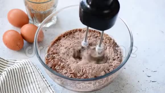 准备巧克力蛋糕用手搅拌机打巧克力面糊视频的预览图
