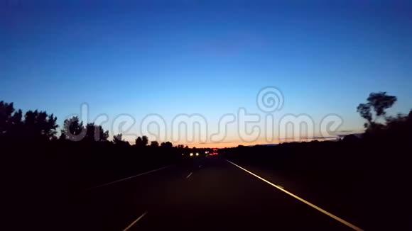 在地平线上用灯光驾驶早晨的高速公路司机观点POV州际驾驶清晨高速公路视频的预览图