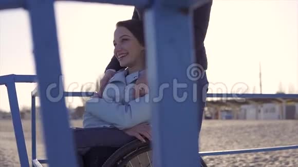轮椅上的残疾青年妇女在坡道上的海边玩得开心视频的预览图