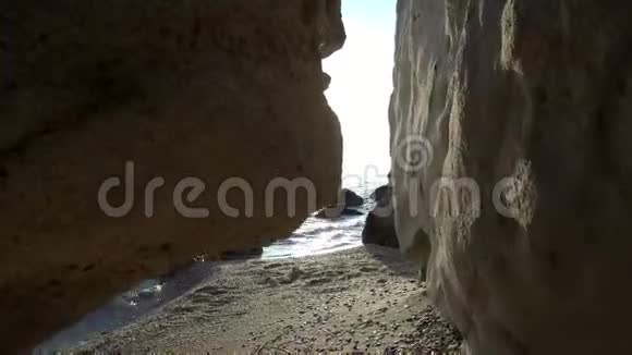 在田园诗般的小海滩上的岩石中观看分辨率4K视频的预览图