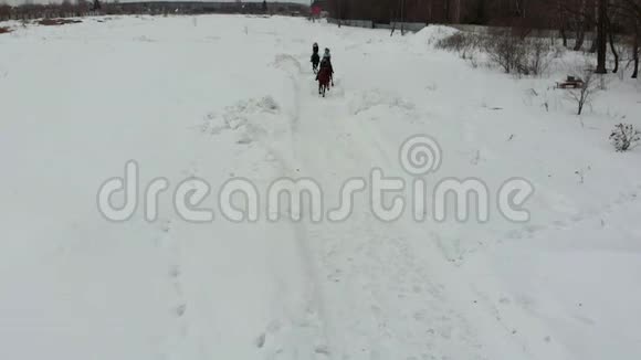 冬天的天气一群年轻的妇女骑马在雪地上视频的预览图