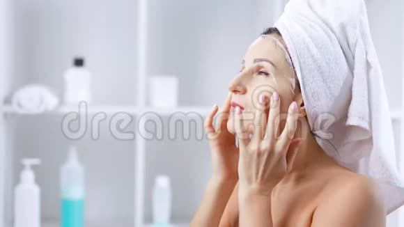 女人用面膜化妆面膜做面部按摩视频的预览图