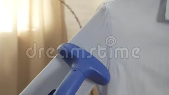 一个男人在家中抚摸蒸煮一件蓝色衬衫视频的预览图