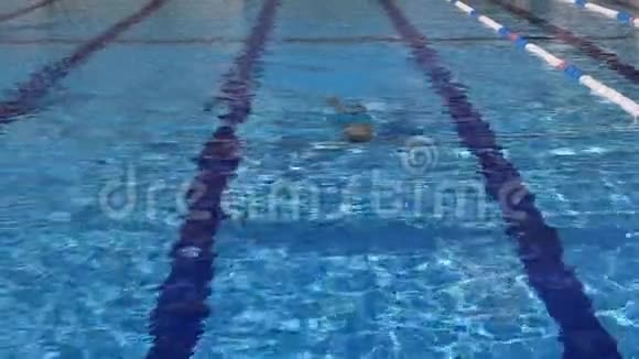 男孩在一个有蓝色水的游泳池里游泳视频的预览图