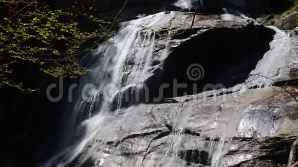 瀑布水流向下流过悬崖和岩石靠近瀑布附近的小溪里泼水透明水晶和灰色视频的预览图