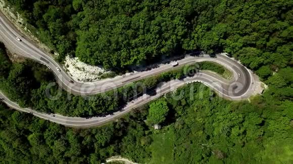 空中飞行在弯曲的蜿蜒的道路下在群山之间视频的预览图
