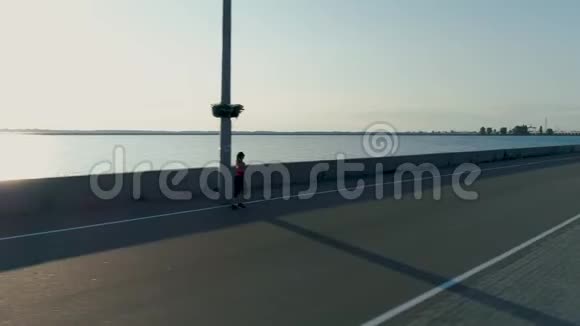 空中射击清晨时分女人在海城的堤岸奔跑视频的预览图