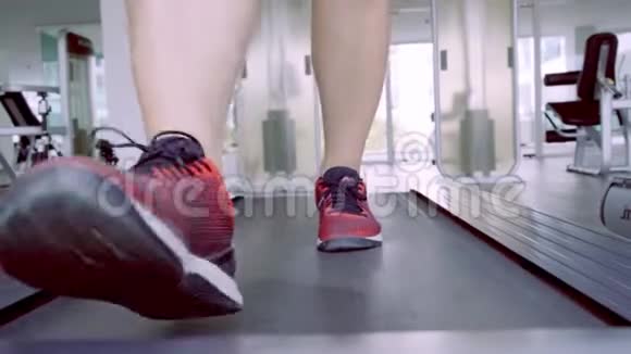 在健身馆里男士们肌肉发达的双腿在跑步机上锻炼视频的预览图