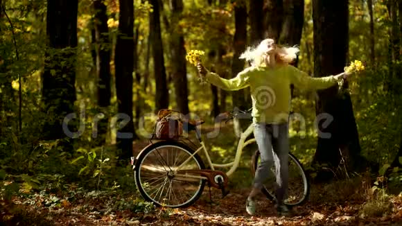 假日户外度假之旅秋天的女人公园里骑自行车的漂亮年轻女人视频的预览图