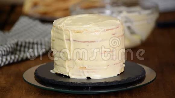 在家里做一层层的拿破仑蛋糕用奶油蛋糕和洒布做成圆形的分层拿破仑蛋糕的过程视频的预览图