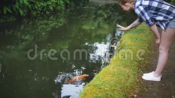 女孩在河里挥舞着一条大红鱼视频的预览图