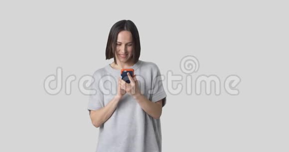 快乐女人在白色背景下使用手机视频的预览图