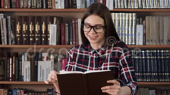青少年喜欢在背景书架上看书视频的预览图