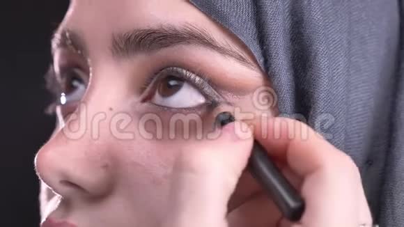 女性用黑色铅笔在黑色头巾上为美丽的穆斯林妇女画箭头视频的预览图