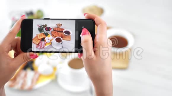 使用智能手机POV拍摄的女性手在餐桌上拍照开胃早餐视频的预览图