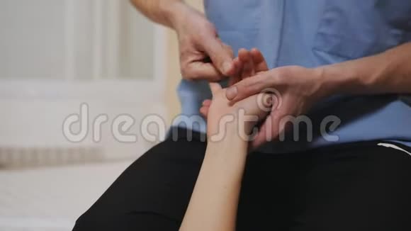 一位按摩治疗师的特写他正在用手指按摩一只手视频的预览图