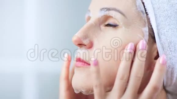 化妆面具的特写肖像女士用手指轻敲脸部视频的预览图