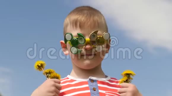 眼镜上的旋转器在旋转在街上玩得很开心小男孩对抗蓝天视频的预览图