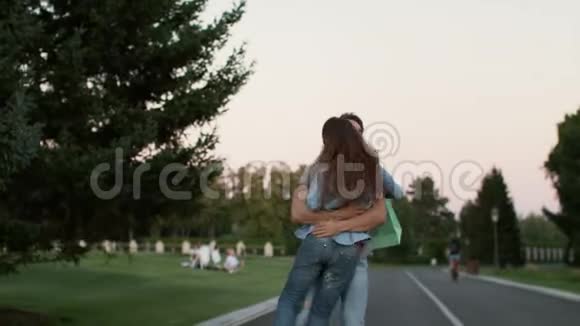 购物成功后一对情侣在夏日公园玩得开心视频的预览图