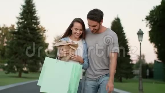 快乐的一对夫妇购物后在街上散步帅哥拥抱幸福女人视频的预览图