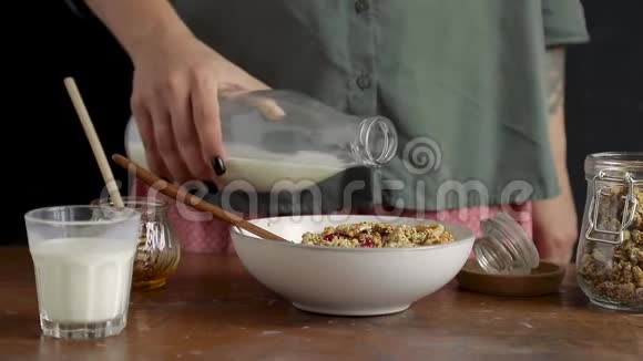 女性用手将牛奶倒入碗中视频的预览图