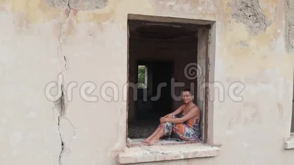 坐在废弃房子窗户上的女人视频的预览图