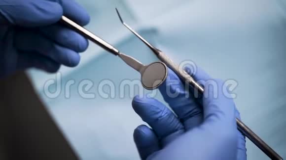 戴手套的牙医拿着诊断工具视频的预览图