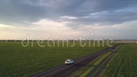 夕阳照亮的汽车沿着狭窄肮脏的道路行驶视频的预览图