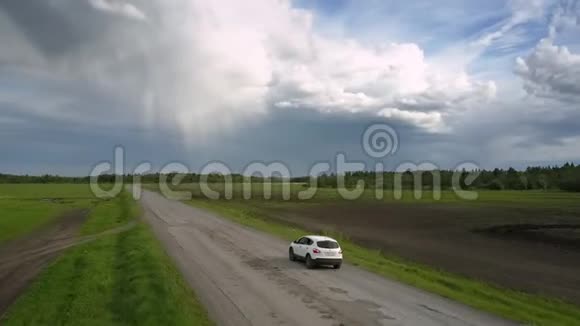 现代汽车沿着毁坏的道路行驶靠近田野上景视频的预览图