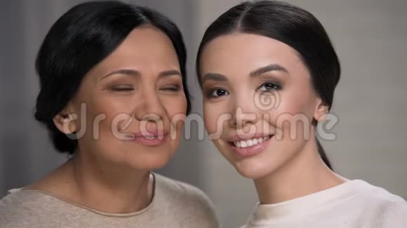 两个微笑的亚洲女人看着镜头母女俩面对特写视频的预览图