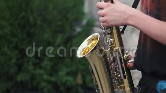 音乐家在城市人行道上演奏萨克斯慢动作视频的预览图