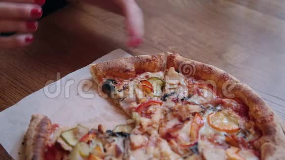 人们手拿切片披萨的特写框架吃一片带奶酪西红柿和火腿的披萨视频的预览图