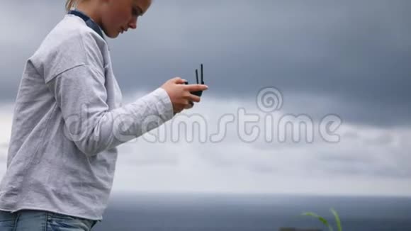 天气不好的女孩驾驶着一架四方直升机在大海的背景下视频的预览图