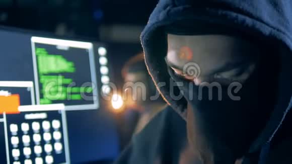 一个男性黑客在近距离工作时伪装的脸视频的预览图