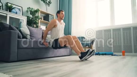 男学生在家里用沙发做俯卧撑用沙发做健美运动视频的预览图